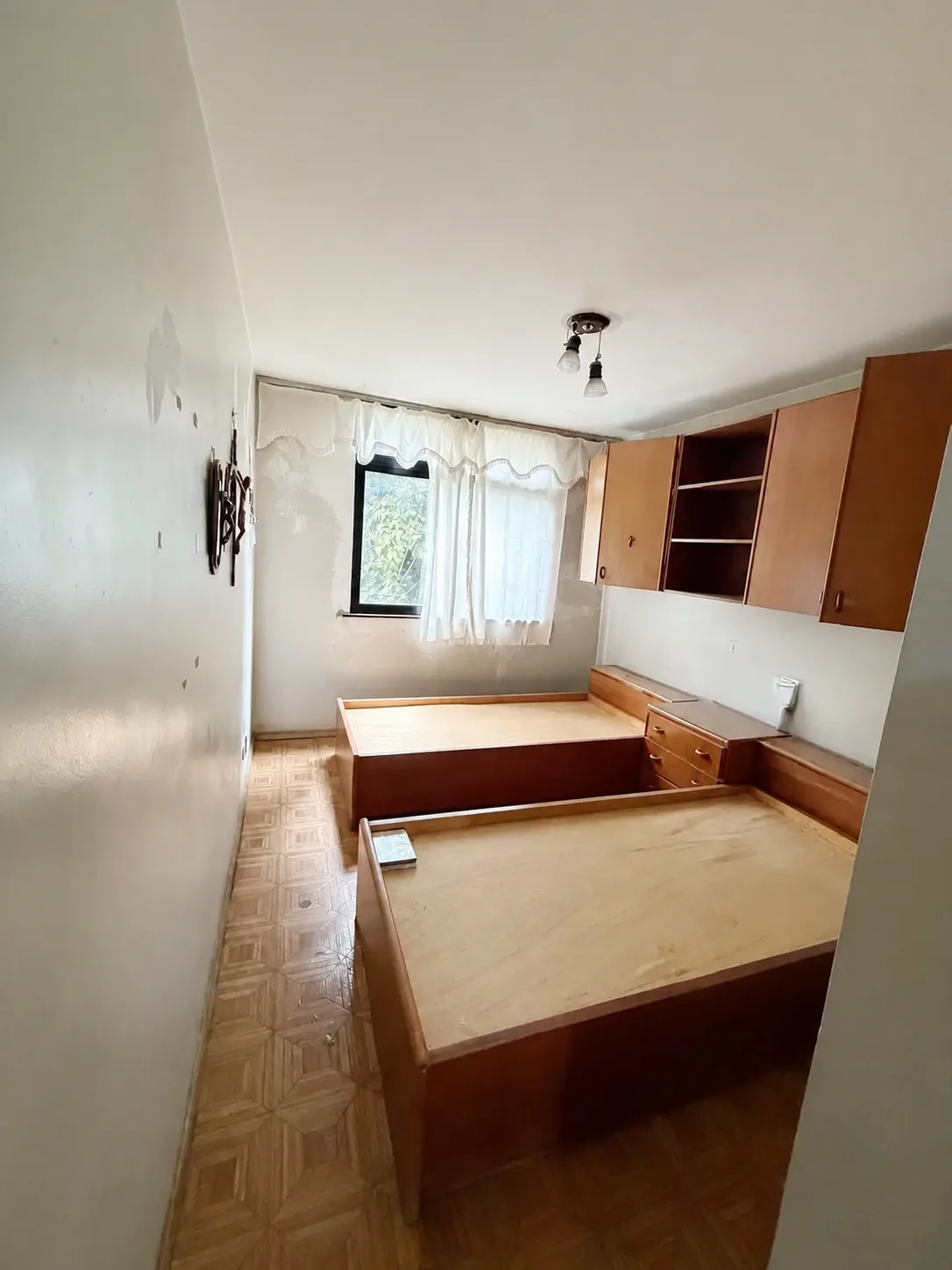 Quarto com móveis de madeira e piso original