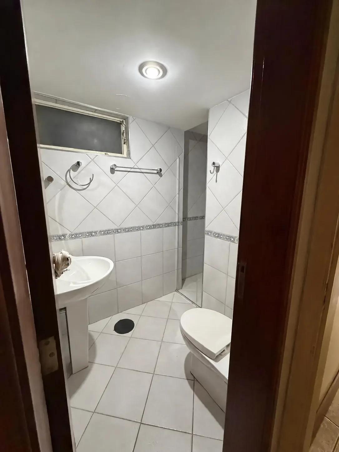 Banheiro com revestimentos claros e box
