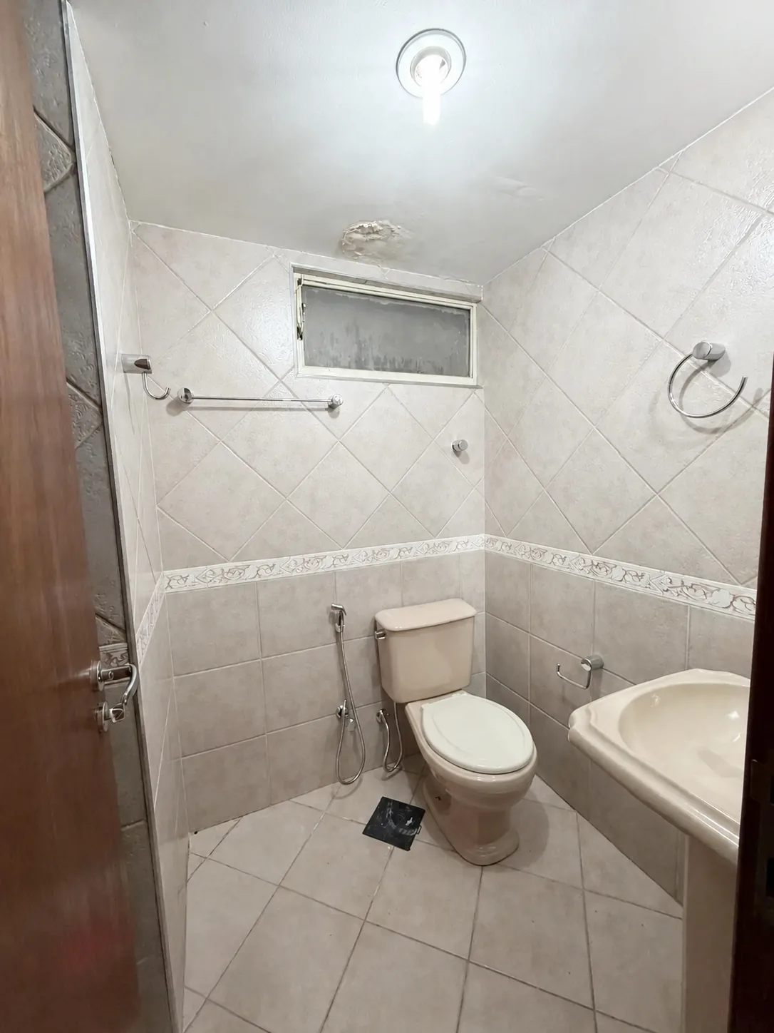 Banheiro com revestimento original e janela alta
