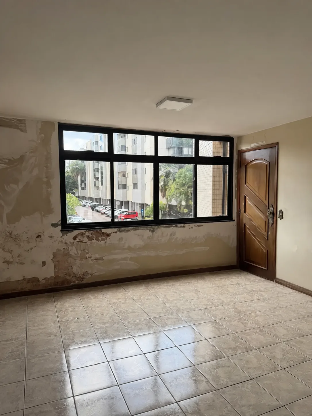 Sala junto à entrada, com janela ampla e acabamento original